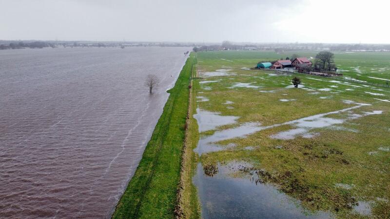 Hochwasserlage: Kampf gegen Überflutung und Aufatmen Ein Wohnhaus am Deich auf der Weserinsel Hagen-Grinden (Aufnahme mit Drohne).