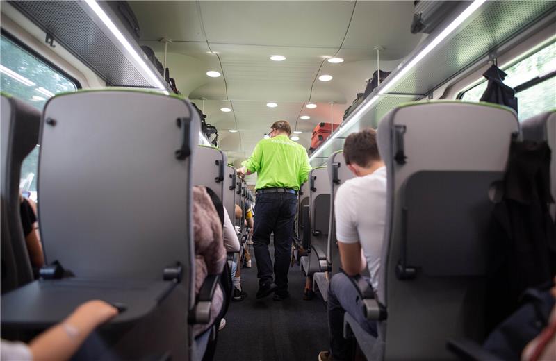 Steckdosen manipuliert: Passagiere erhalten Stromschlag im Flixtrain nach Hamburg Ein Zugbegleiter geht durch einen Flixtrain. In zwei Zügen wurden die Steckdosen manipuliert, Passagiere erlitten gefährliche Stromschläge. Foto: Daniel Reinhardt/dpa