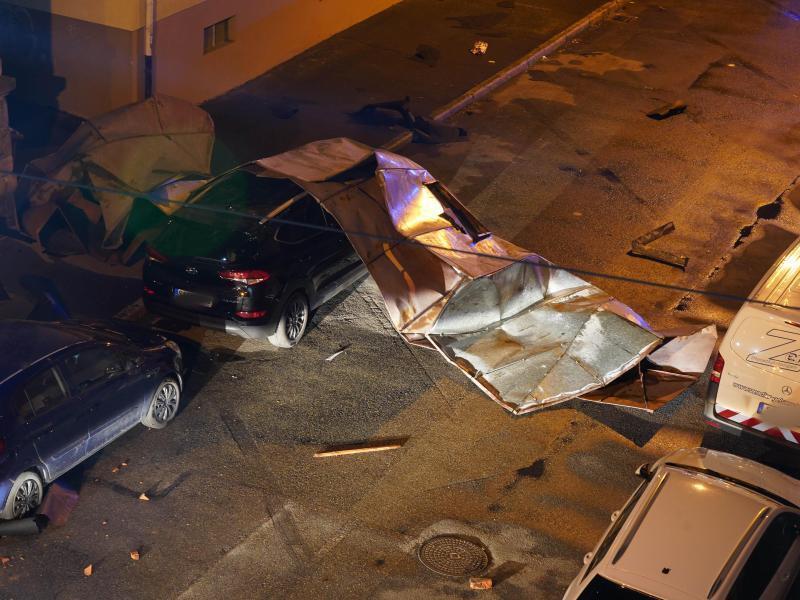 Ein abgedecktes Dach liegt auf einer Straße mit mehreren geparkten Autos in Stuttgart. Foto: Andreas Rosar/Fotoagentur-Stuttgart/dpa