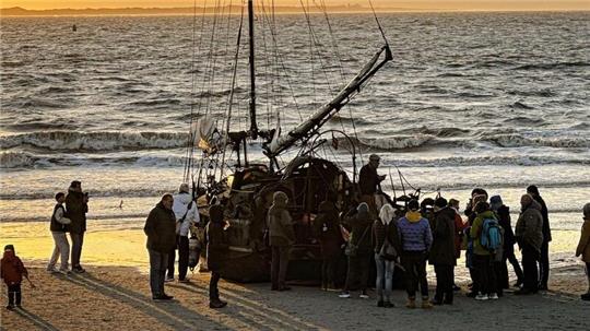 Ein am Weststrand der Insel Norderney gestrandetes Segelschiff mit Schaulustigen.