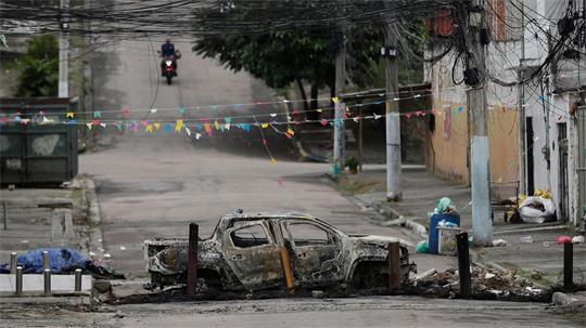 Ein ausgebranntes Auto versperrt eine Straße in der Favela „Complexo de Israel“, nahe weiterer Favelas, in denen die Polizei derzeit Razzien gegen Drogenbanden durchführt.