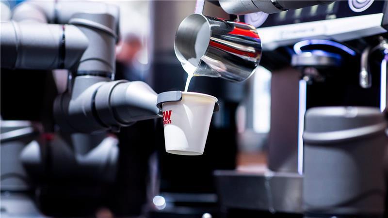 Ein automatisierter Barista-Automat bereitet unter Nutzung von industriellen Roboterarmen einen Kaffee zu am Messestand von SEW Eurodrive bei der Industriemesse Hannover Messe 2025.