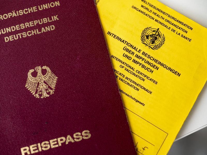 Ein deutscher Reisepass (l) liegt neben einem Impfbuch. Foto: Fabian Sommer/dpa/Symbolbild