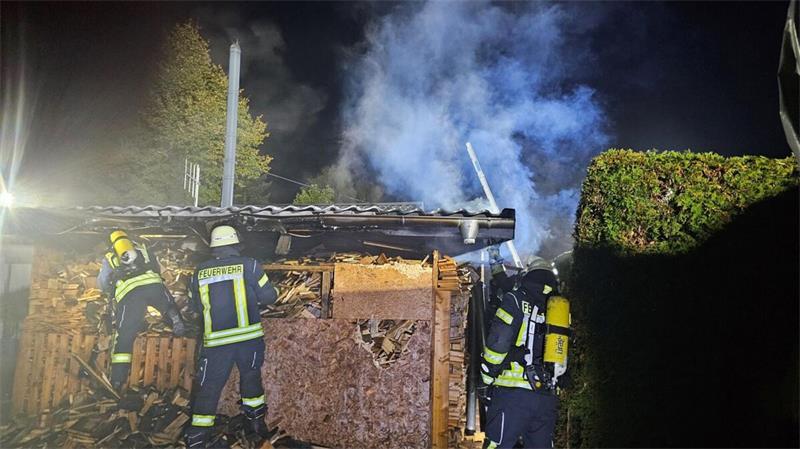 Ein direkt an ein Wohnhaus mit angrenzender Garage angebrachter Brennholzlagerunterstand geriet aus bislang ungeklärter Ursache in Brand.