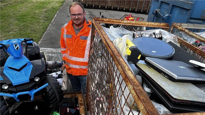 Ein elektrisches Kinderquad, jede Menge Notebooks und dazwischen piepende Rauchmelder: Tobias Güldenpfennig zwischen den Gitterboxen voller Elektro-Altgeräte.