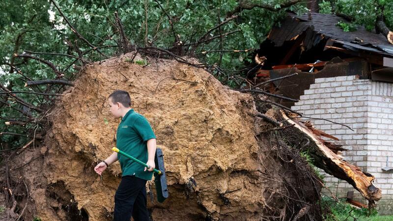 Ein entwurzelter Baum, der auf ein Haus gestürzt ist, nachdem starker Wind und Regen über Houston hinweggefegt waren.