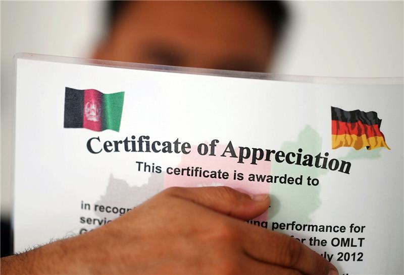 Keine Einreisen über Afghanistan-Aufnahmeprogramm Ein geflüchteter Mann, der als afghanische Ortskraft tätig war, zeigt ein Zertifikat, das nach seinen eigenen Angaben die Zusammenarbeit mit der Bundeswehr in Afghanistan würdigt.
