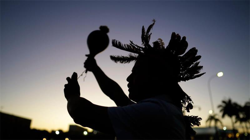 Ein indigener Mann führt während einer Demonstration ein Ritual durch.