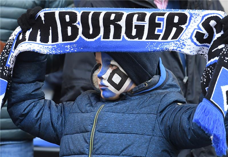 Ein junger HSV Fan hält den Schal hoch und hat sich die Raute ins Gesicht gemalt. Fot: Carmen Jaspersen/dpa