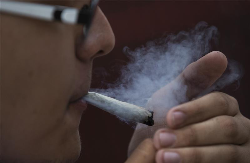 Ein junger Mann raucht Marihuana. Foto: Marco Ugarte/AP/dpa
