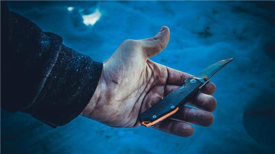 Ein Mann hält ein Messer in der Hand.