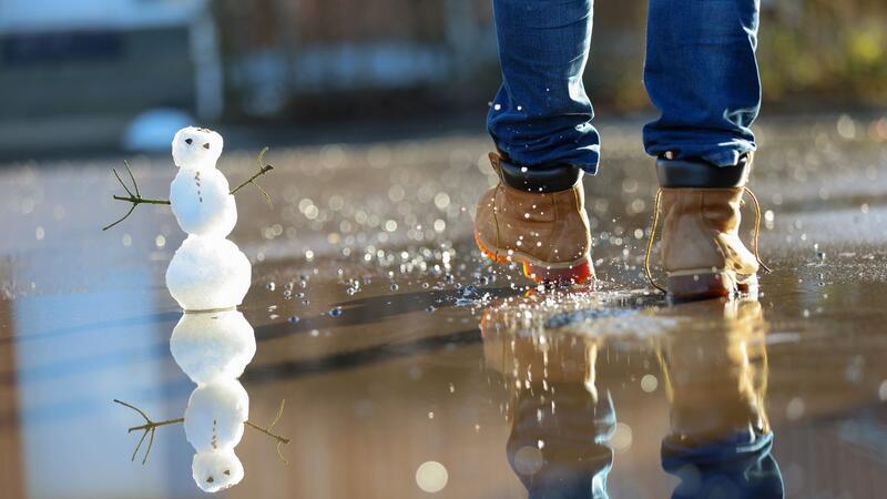 Der Schnee taut - Wasserstände steigen Ein kleiner Schneemann in einer Pfütze.
