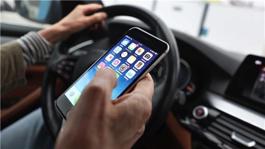 Ein „kurzer“ Blick auf das Handy ist bisher erlaubt - wenn man es nicht in die Hand nimmt. (Symbolbild)
