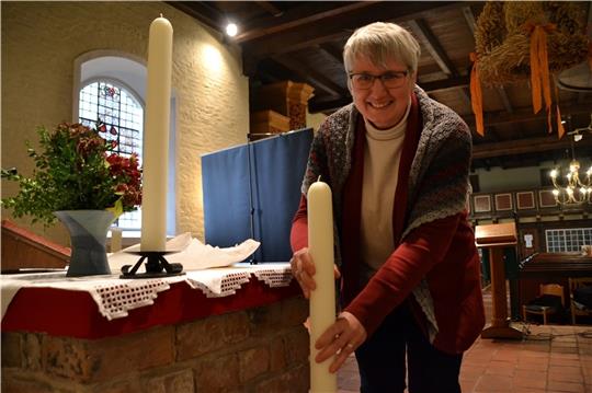 Ein letztes Mal tauscht Sabine Müller nach einem Gottesdienst die Altarkerzen in der Baljer Kirche aus. Foto: Helfferich