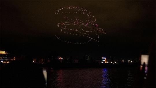 Ein leuchtendes Fischbrötchen aus Drohnen im Hamburger Hafen. 