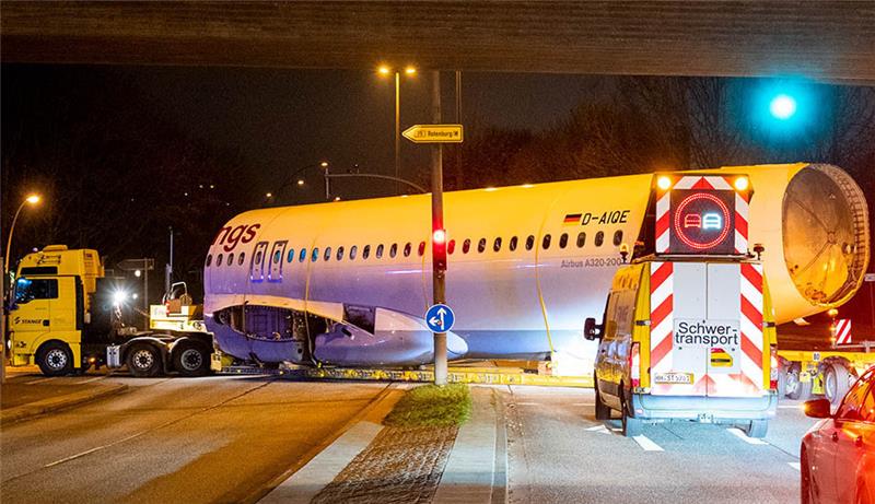 Ein mit einem Airbus-Flugzeugrumpf beladener Schwertransport fährt zum Zentrum für Angewandte Luftfahrtforschung (ZAL). Das Teil des ehemaligen Flugzeugs wurde in der Nacht von der Lufthansa Technik zum ZAL für Forschungszwecke gebracht. Foto: Daniel Bockwoldt/dpa