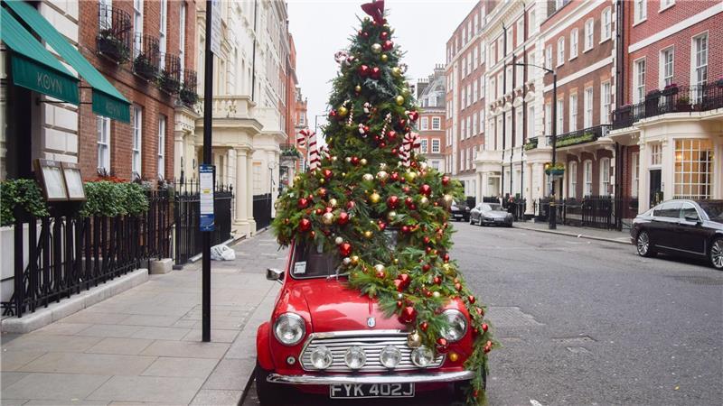 Ein mit einem Weihnachtsbaum geschmückter Mini steht in London auf der Straße.