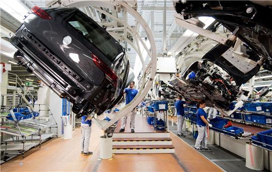 Ein neuer Volkswagen Golf 8 (l) schwebt an einer Produktionslinie im VW Werk.