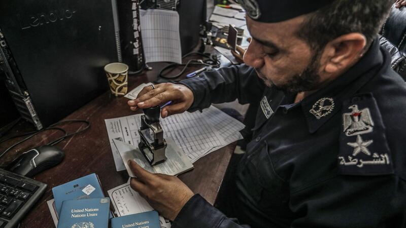 Geschäft mit Menschen: Gaza-Ausreise für 10.000 Dollar Ein palästinensischer Beamter kontrolliert die Pässe: Können die Menschen den Gazastreifen in Richtung Ägypten verlassen?