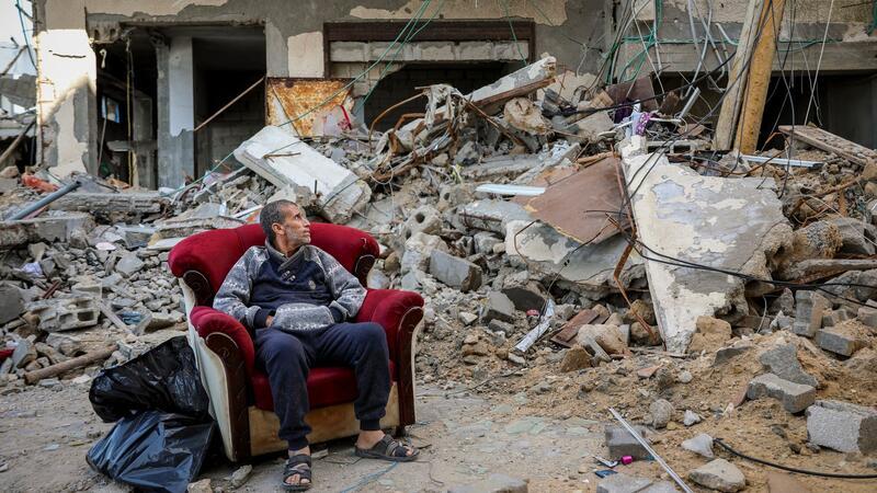Wie geht es weiter mit der Feuerpause - und danach? Ein palästinensischer Mann sitzt in einem Sessel vor einem zerstörten Gebäude in Gaza-Stadt.