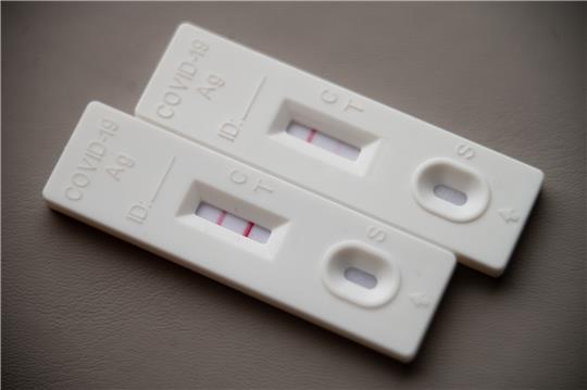 Ein positiver Corona-Schnelltest (l) liegt auf einem Tisch neben einem Corona-Schnelltest, der schwach eine positive Linie hat. Foto: Sebastian Gollnow/dpa