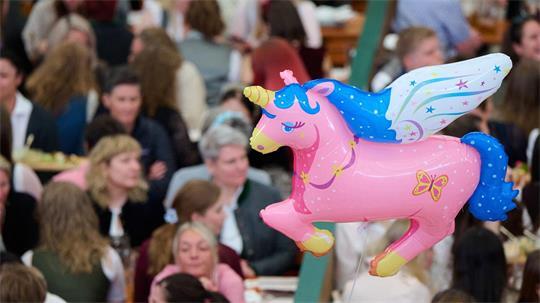 Ein rosa Einhorn schwebt über der Veranstaltung.