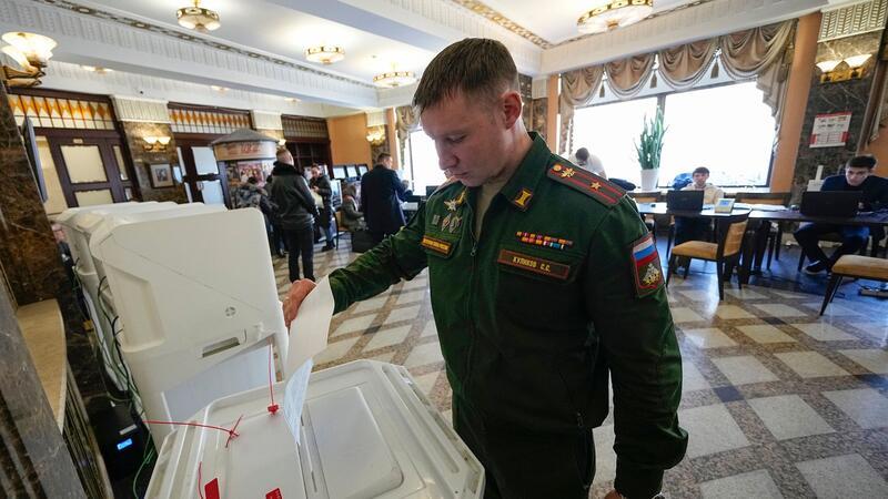 Präsident „gesucht“: Putin lässt wählen Ein russischer Soldat gibt während der Präsidentschaftswahl in einem Wahllokal Moskau seine Stimme ab.