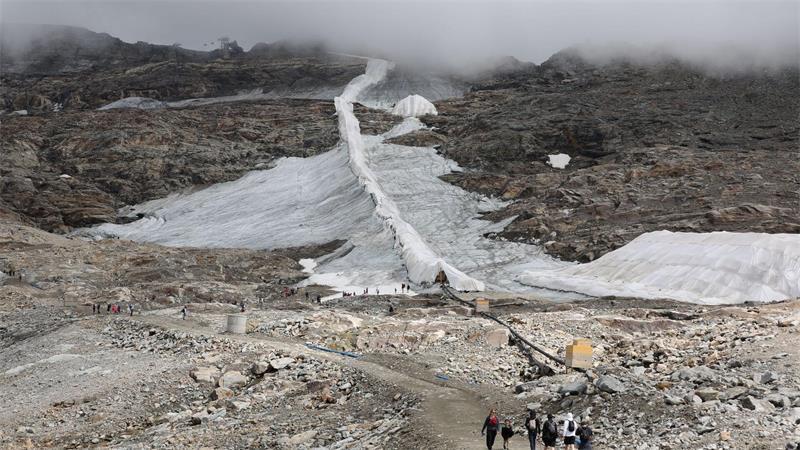 Ein schmales Schneeband: Menschen sind am Mölltaler Gletscher in Kärnten unterwegs.
