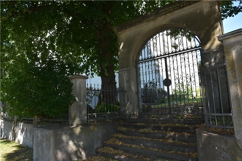 Ein schmiedeeisernes Tor führt in den Garten des ehemaligen imposanten Anwesens.