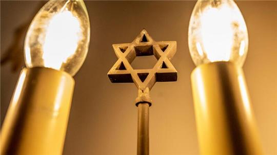 Ein siebenarmiger Leuchter (Menora) mit einem Davidstern in einer Synagoge.