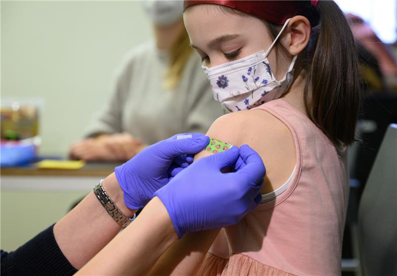 Ein siebenjähriges Mädchen bekommt nach ihrer Impfung ein Pflaster auf den Arm geklebt. Foto: Robert Michael/dpa-Zentralbild/dpa