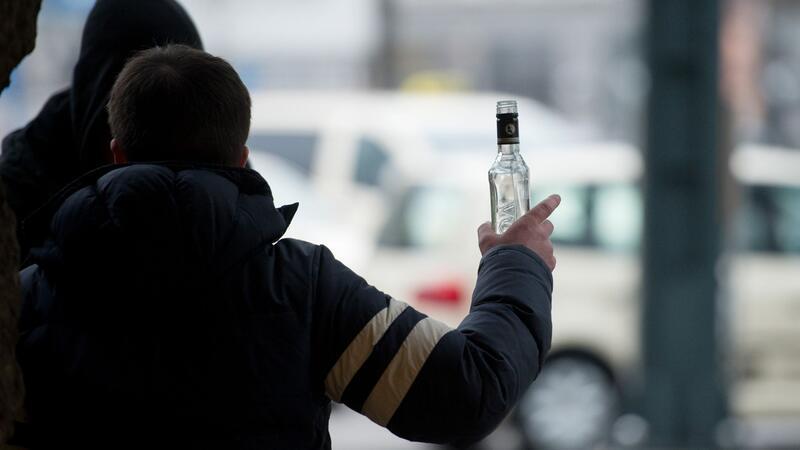 Ein stark alkoholisierter Mann gestikuliert am Hauptbahnhof in Hamburg mit einer Wodkaflasche in der Hand.