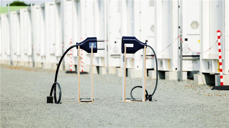 Ein symbolischer Stecker steht auf dem Gelände eines neuen Batteriegroßspeichers in Bollingstedt. Wesentlich kleiner ist das Projekt, das die Firma Solar215 in Oldendorf bauen will.