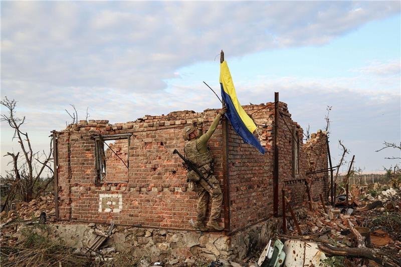 Ein ukrainischer Kommandeur hisst die Nationalflagge als Symbol der Befreiung des Frontdorfes Andrijewka in der Region Donezk.