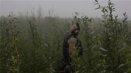 Ein ukrainischer Marinesoldat geht durch ein Gelände an der Frontlinie nahe des Flusses Dnepr.