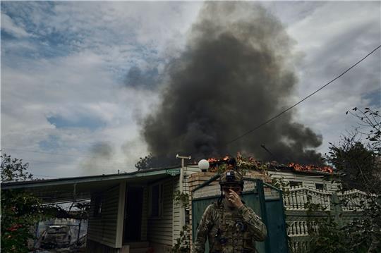 Ein ukrainischer Soldat geht an einem Haus vorbei, das nach einem Beschuss in der Nähe der Frontlinie abgebrannt ist. Russland führt seit Februar 2022 Krieg gegen die Ukraine.