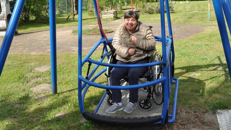 Ein ungewohntes Bild: Ein Mensch im Rollstuhl schaukelt auf dem Gelände des DRK-Kreisverbands Stade.