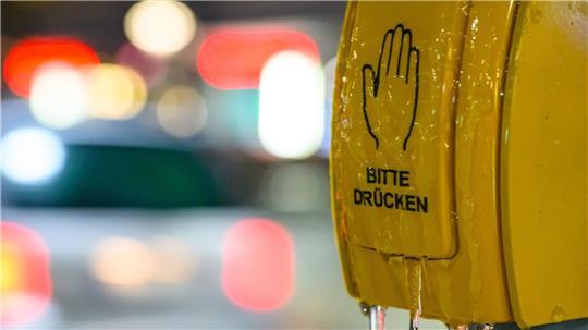 Ein vereister Tastschalter ist an einer Haltestelle in Brandenburg am frühen Morgen zu sehen.