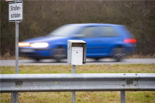 Ein weißer Briefkasten steht zwischen vorbeifahrenden Autos auf dem Mittelstreifen der A 20 nahe dem Übergang zur B 206. Foto: Jonas Walzberg/dpa