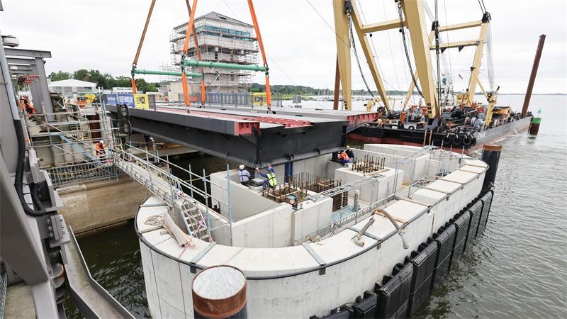 Ein wichtiges Stück der neuen Brücke wird vom Schwimmkran an die richtige Position gehoben.