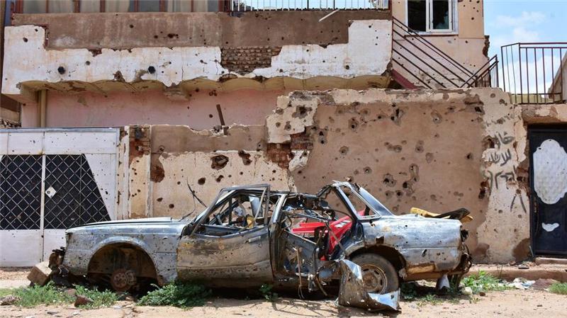 Militärflugzeug stürzt über Wohngebiet im Sudan ab - 46 Tote Ein zerstörtes Auto steht im sudanesischen Omdurman vor einem Haus voller Einschüsse. (Archivbild)