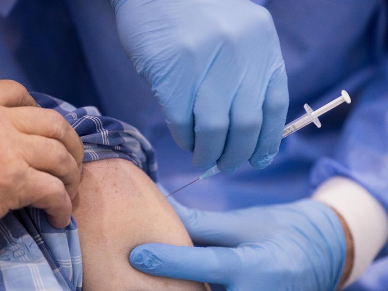 Ein Arzt impft einen Mann. Foto: Rolf Vennenbernd/dpa/Symbolbild