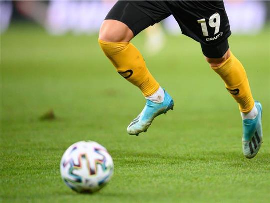 Ein Fußballspieler spielt den Ball. Foto: Robert Michael/dpa-Zentralbild/dpa/Symbolbild