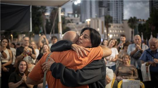 Zwei Israelis umarmen sich, während sich Menschen auf dem Geiselplatz in Tel Aviv versammeln, um das Waffenstillstandsabkommen zu feiern.