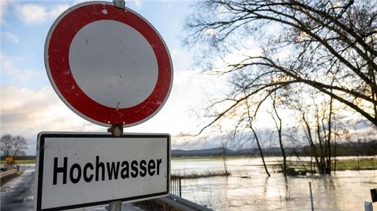 Eine Absperrbake und ein Schild mit der Aufschrift „Hochwasser“.