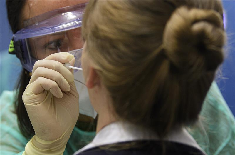 Eine Ärztin der Kassenärztlichen Vereinigung nimmt bei einer Frau einen Abstrich für einen Coronavirus-Test. Foto: Robert Michael/dpa