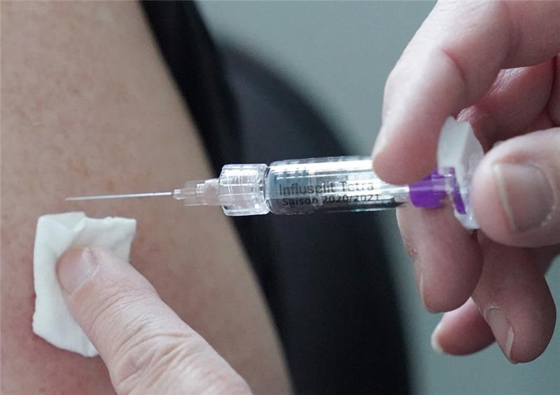 Eine Ärztin impft eine Person mit dem Arzneimittel Influsplit Tetra gegen Grippe. Foto: Marcus Brandt/dpa