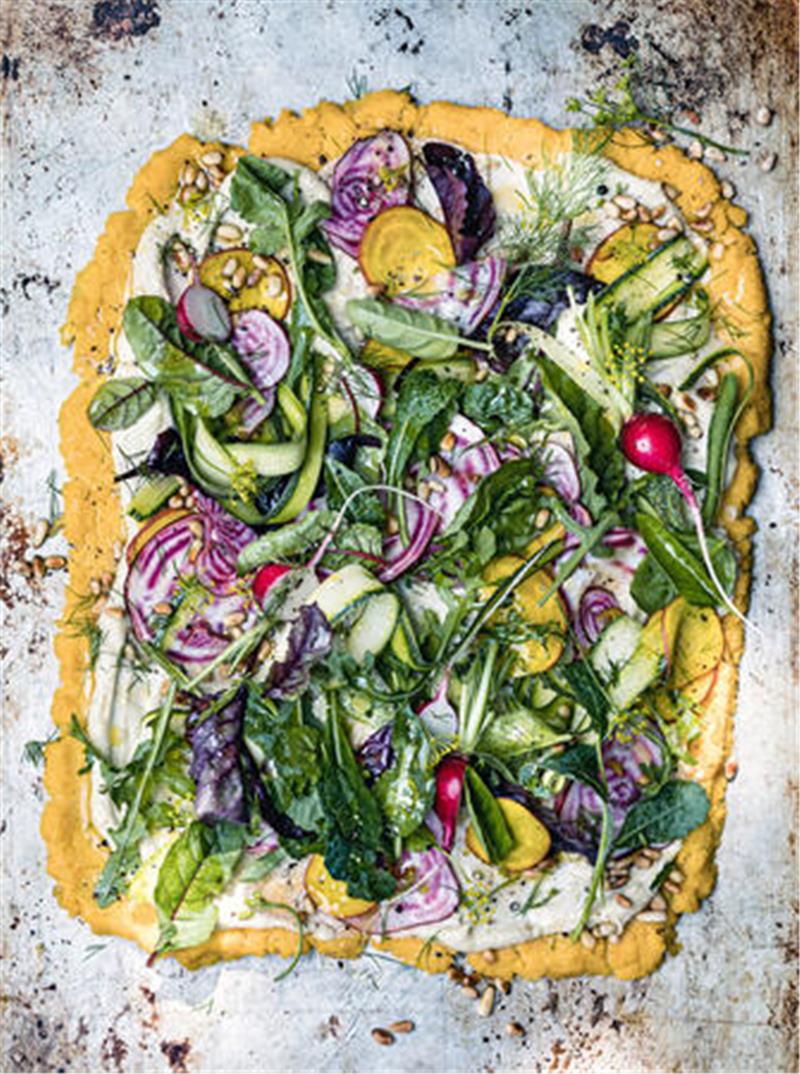 Eine Alternative zur klassischen Pizza ist die Variante mit Polenta-Boden. Sie wird mit einer Ricotta-Cashew-Creme und Salat getoppt.