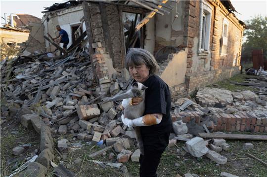 Eine Anwohnerin steht vor ihrem Haus, das durch einen Raketenangriff in Kostjantyniwka in der Region Donezk beschädigt wurde.