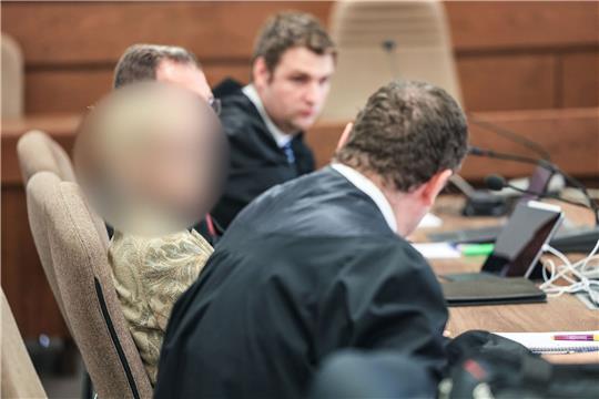 Eine Apothekerin (l.) sitzt im Landgericht zwischen ihren Anwälten auf der Anklagebank.